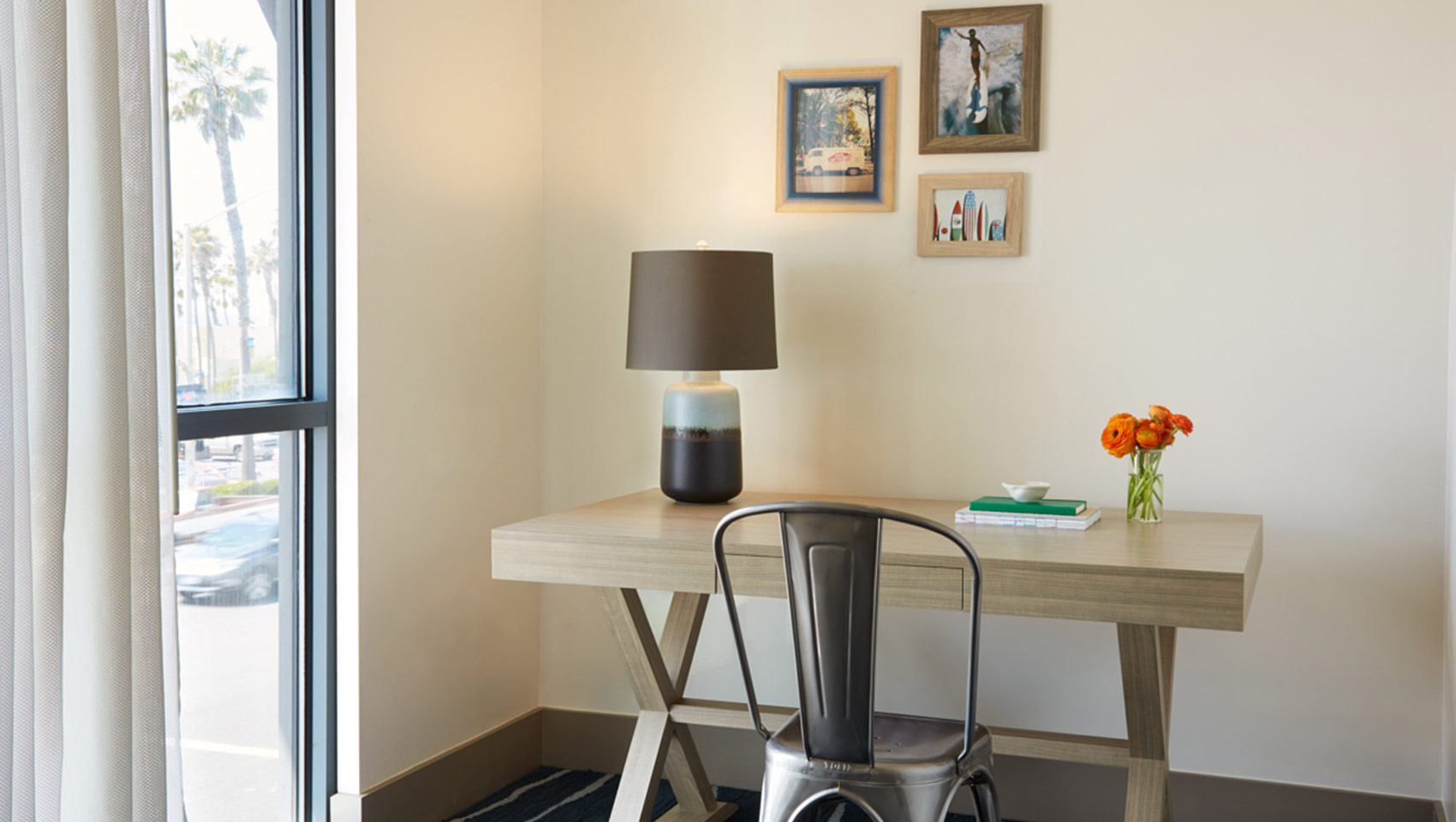 Desk with chair and lamp in guestroom at Kimpton shorebreak resort