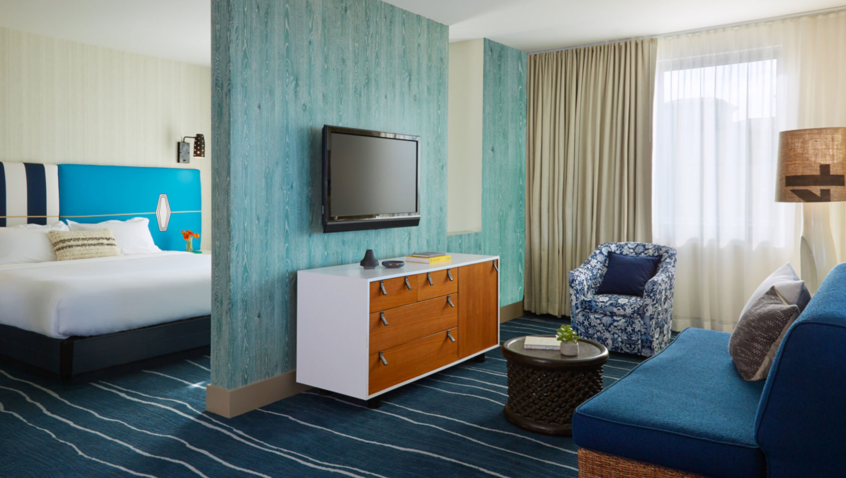 Suite sitting area with view of guest bed at Kimpton shorebreak resort