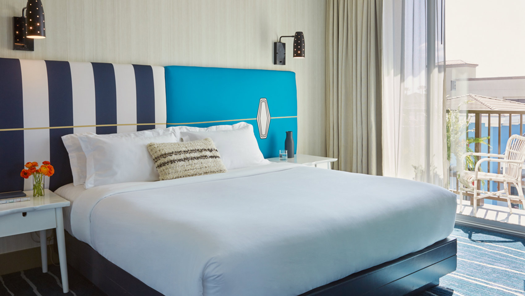 King bed with view of balcony at Kimpton Shorebreak Resort