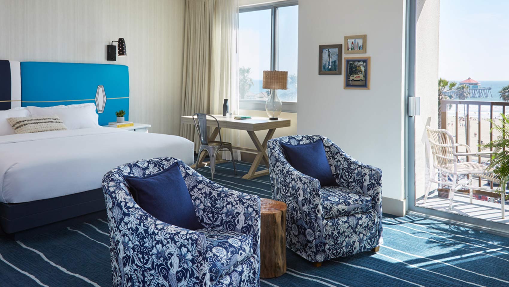 King bed  and chairs with view of balcony at Kimpton Shorebreak Resort